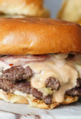 Juicy Smash Burger Sliders served with toppings on a wooden board