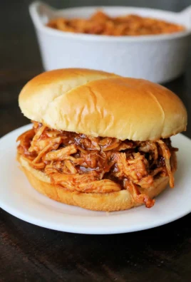 Delicious crockpot BBQ chicken served with sides on a wooden table