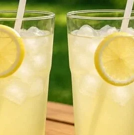 Glass of refreshing homemade lemonade with lemon slices and mint leaves