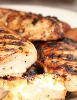 Perfectly grilled chicken breasts on the barbecue grill with seasonings