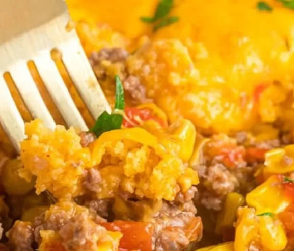 A hearty Mexican Cornbread Casserole topped with cheese and fresh ingredients.