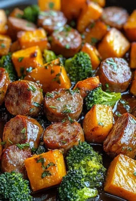 Sheet pan sausage with sweet potatoes and honey garlic sauce on a baking tray